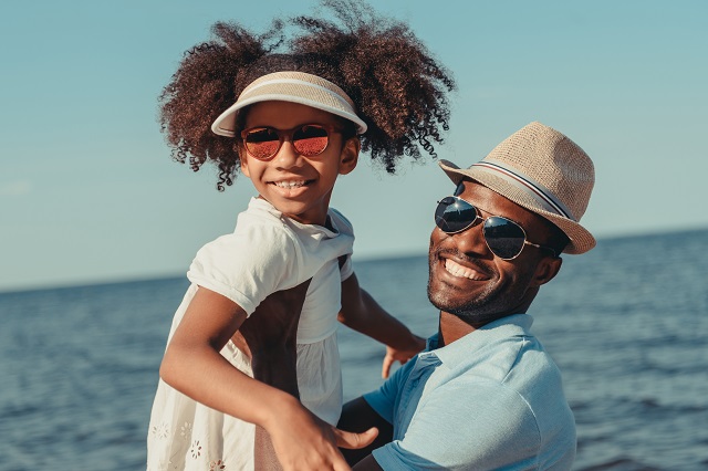 happy african american father and daughter in sunglasses